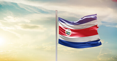 Costa Rica national flag waving in beautiful sky. The symbol of the state on wavy silk fabric.