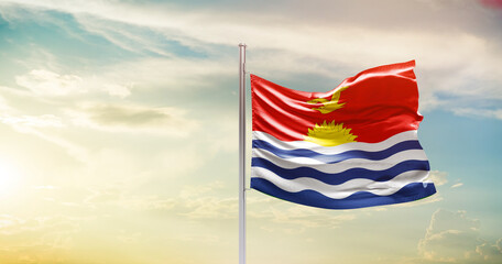 Kiribati national flag waving in beautiful sky. The symbol of the state on wavy silk fabric.