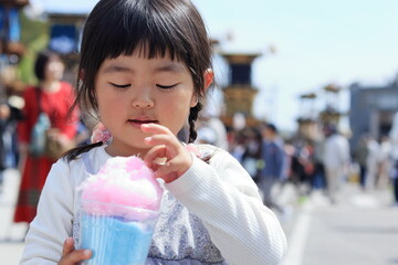 お祭りで綿菓子を食べる子供