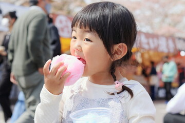お祭りで綿菓子を食べる子供