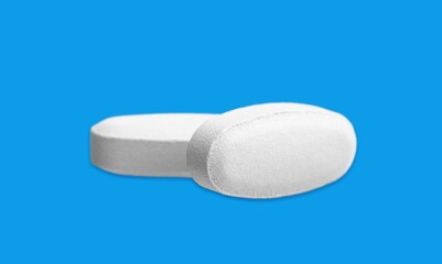 white medical pills lie on a color background.