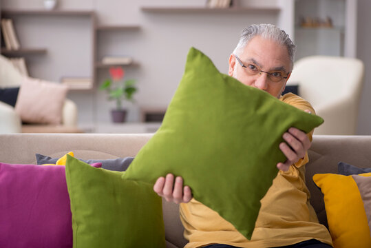 Old man with many pillows at home