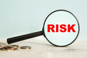 magnifier, coins. risk. business concept