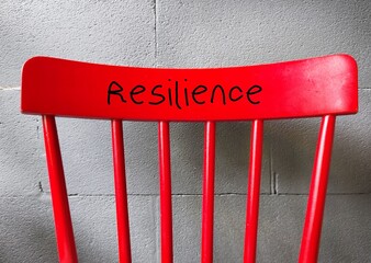 Red chair with handwritten RESILIENCE, means capacity to recover quickly from difficulties and...