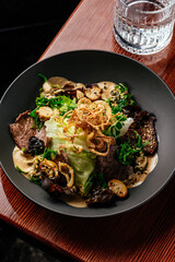 warm salad with beef, vegetables and herbs. restaurant menu