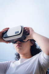 Young woman wearing virtual reality mask in a cloudy day