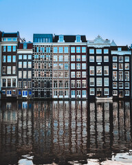 eflection of Amsterdam apartments on water canal