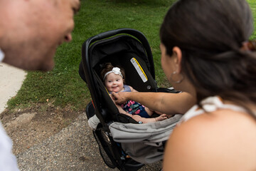 Parents looking at special needs infant in carseat