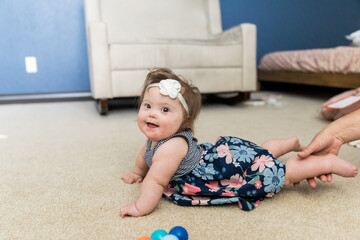 Happy special needs infant playing inside