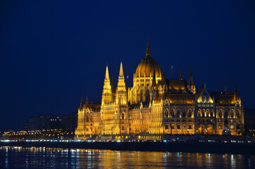 Fototapeta na wymiar Parliament building in Budapest on embankment of Danube at night.