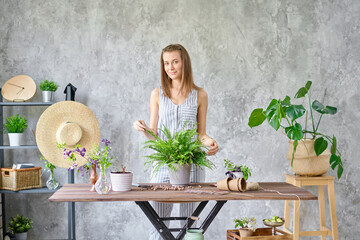 Woman transplanting a fern, a houseplant. Concept of home garden. Flower and garden shop.