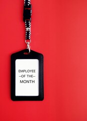 Employee staff ID card  with text written EMPLOYEE OF THE MONTH on red background, refers to...