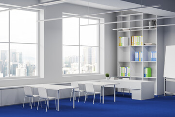 White and blue classroom interior with desk in row and shelf near window