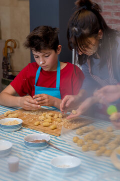 Cheerful teen concentrated working with traditional catalonian p