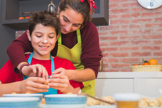 Brothers working with dough and decorating catalonian pastry at