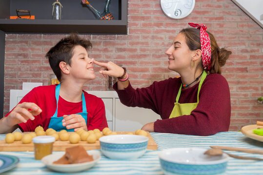 Brothers playing with dough and flour while working on pastry at