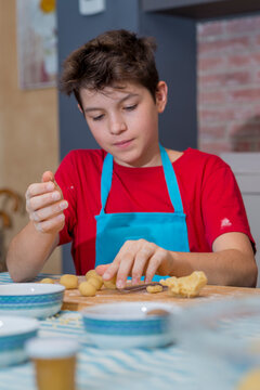 Cheerful teen concentrated working with traditional catalonian p