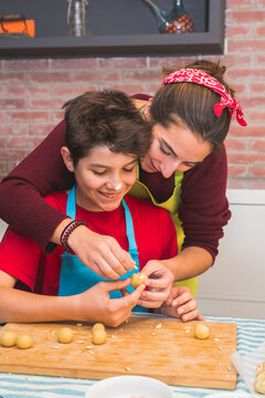 Brothers working with dough and decorating catalonian pastry at