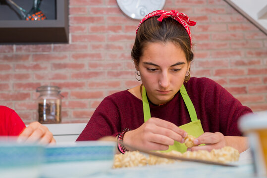 Cheerful teen concentrated working with traditional catalonian p