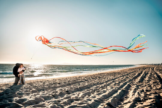 Dad and Daughter Flying Kite at Beach