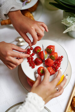 Hands helping themselves to delicious looking fruit platter