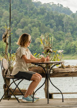 Woman sitting looking at her mobile phone in khao sok national park