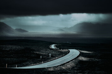 Iceland road view in a claudy winter day, glacier in the background.