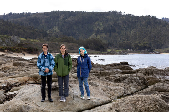 Siblings Standing By The Coast In Monterey California