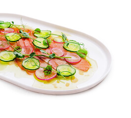Buffet serving of pickled salmon slices with radish, cucumber