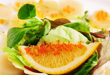 fresh scallops with red caviar on plate