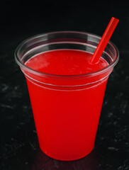 red juice into glass over black background