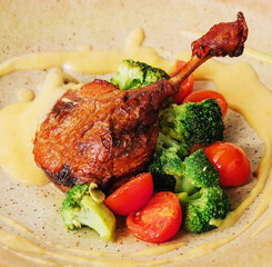 Confit duck leg with broccoli and tomatoes