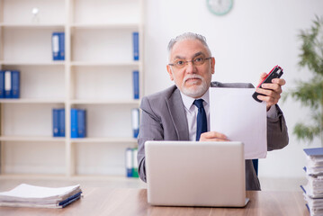 Old male employee working in the office