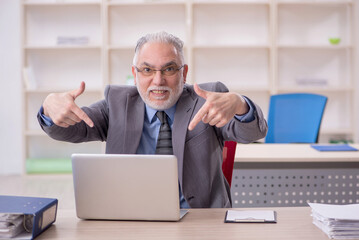 Old male employee working in the office