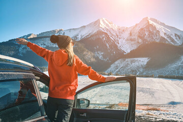Happy Female in car enjoying winter mountain landscape, Woman traveling exploring, enjoying the...