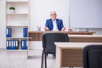 Old male teacher in the classroom