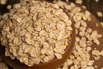 Oat flakes poured into a wooden bowl