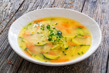 Broth - chicken soup with vegetables on wooden table

