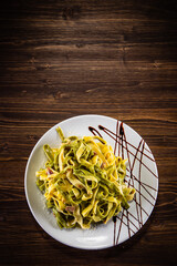 Tagliatelle with parmesan and bacon on wooden table

