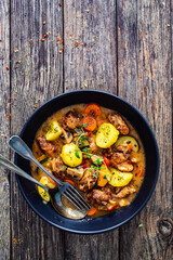 Delicious stew - cooked vegetables with roast meat on wooden table
