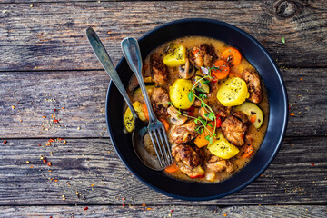 Delicious stew - cooked vegetables with roast meat on wooden table
