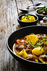 Delicious stew - cooked vegetables with roast meat on wooden table
