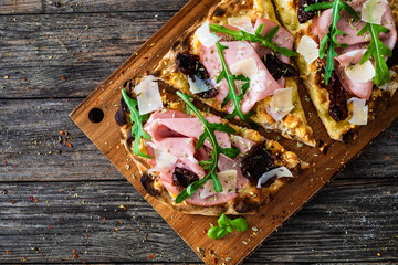 Pinsa Romana with mortadella, parmesan cheese and vegetables on wooden table  © Jacek Chabraszewski