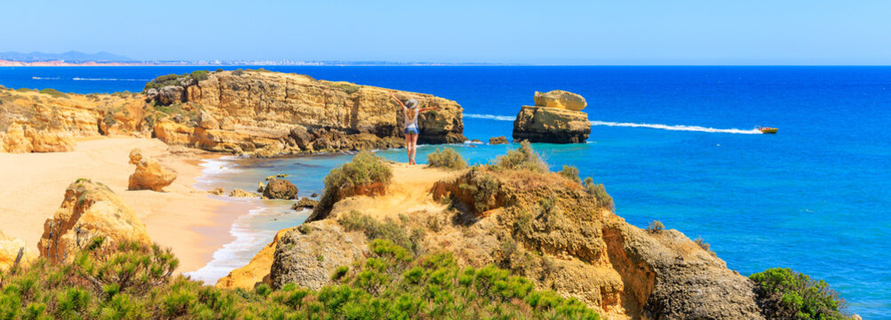 Woman tourist enjoying panoramic view of beautiful algarve beach- travel destination, summer vacation travel concept- Portugal ( praia da Marinha, carvoeiro, benagil)