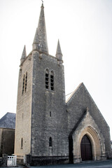 Fototapeta na wymiar Saint-Martin-de-Vareville. Eglise Saint-Martin de face en contre-jour le matin. Manche. Normandie 