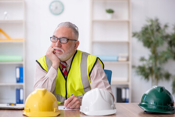 Old male architect sitting in the office