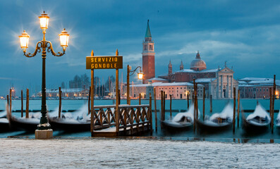 Fototapeta na wymiar Venezia. Neve con gondole al palo alle fondamenta di San Marco verso San Giorgio Maggiore all' alba.