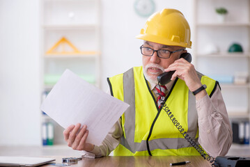 Old male architect sitting in the office