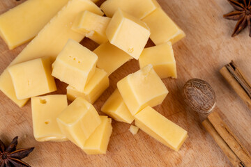 Yellow hard cheese sliced on a board