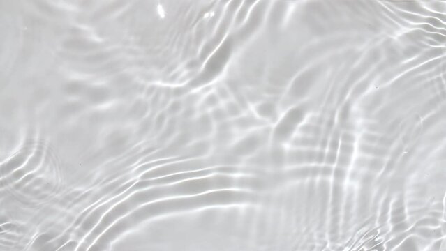 Pure water with reflections sunlight in slow motion. Water surface texture top view. Sun and shadows. Motion clean swimming pool ripples and wave. High quality 4k footage